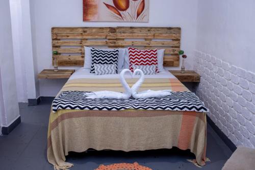 a bedroom with two swans on a bed at Pousada Pelô de Imbassaí in Imbassai