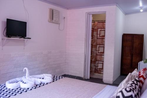 a living room with a couch and a tv at Pousada Pelô de Imbassaí in Imbassai