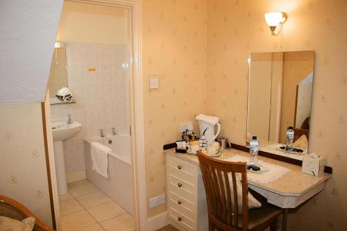 a bathroom with a sink and a toilet and a tub at The Chudleigh in Clacton-on-Sea