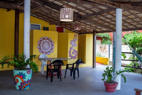 a patio with a table and chairs and a yellow wall at Pousada Pelô de Imbassaí in Imbassai