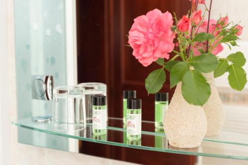 szklany stół z wazonem kwiatów i wazonem kosmetyków w obiekcie Rooms Cvitar - Center w mieście Kranjska Gora