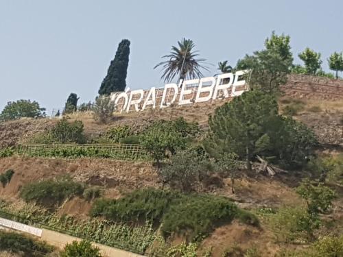 a sign on top of a hill with trees at River Ebro Apartments in Móra d'Ebre