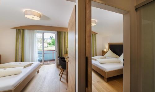 um quarto de hotel com duas camas e uma varanda em Hotel Garni Sohler em Villach