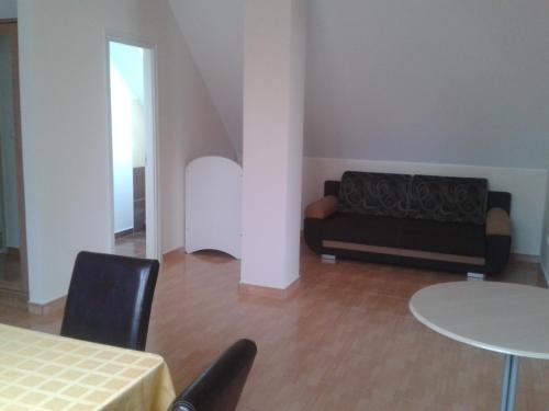 a living room with a couch and a table at Határmenti Vendégház in Zsira