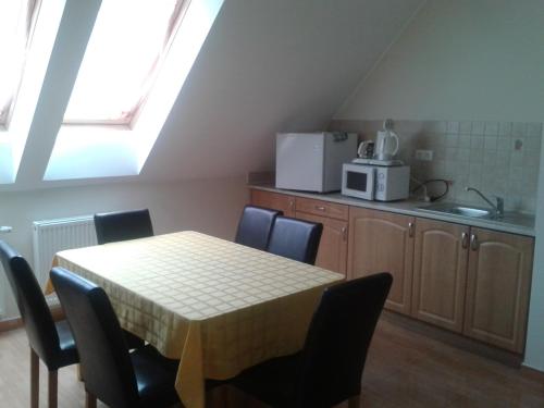 a kitchen with a table and some chairs and a microwave at Határmenti Vendégház in Zsira