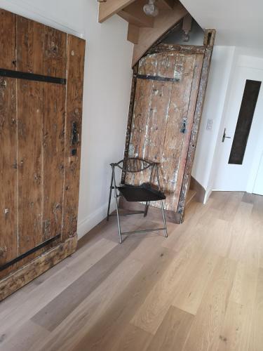 a black chair sitting in front of a large wooden door at Cottage AU TERMINUS 2 climatisé in Hautvillers