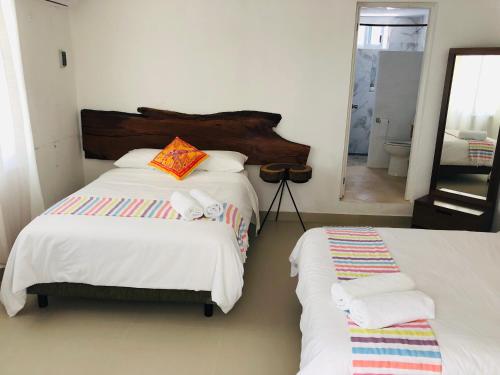 a bedroom with two beds and a mirror at Casa Bizu in Bacalar