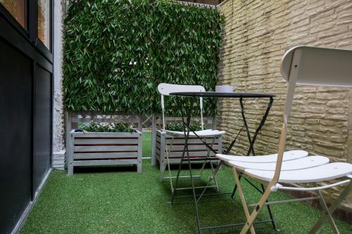 a patio with two chairs and a table and some plants at Sammartino suite in Palermo