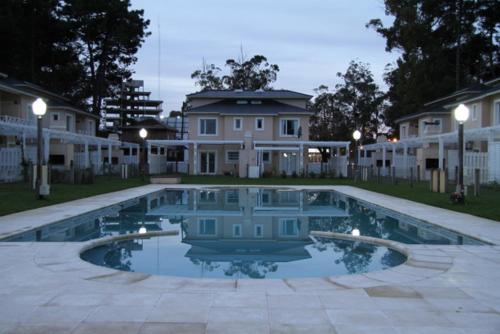 a large swimming pool in front of a house at Complejo Tridente in Pinamar