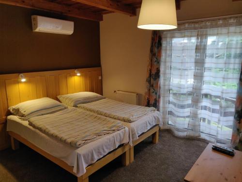 sypialnia z 2 łóżkami pojedynczymi i oknem w obiekcie Vilma Villa w mieście Balatonmáriafürdő