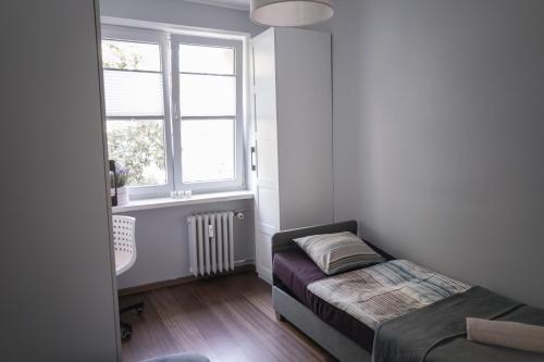 グディニャにあるCharming Apartment Gdynia Boulevardの小さなベッドルーム(ベッド1台、窓付)