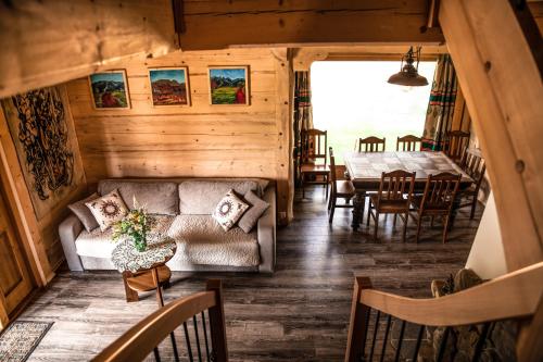 ein Wohnzimmer mit Sofa und Tisch in der Unterkunft Domki i Apartamenty Na Wyskówkach Jacuzzi & Sauna in Zakopane