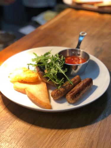 a plate of food with sausages and bread and a bowl of sauce at The Fleece Hotel Richmond in Richmond