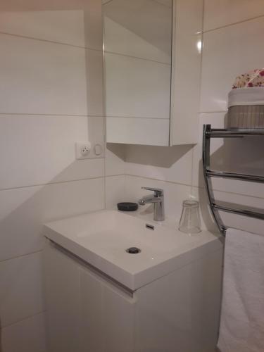 uma cozinha branca com um lavatório e um espelho em L'appart em Reims