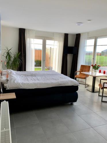 a bedroom with a bed and a table and chairs at Groede B&B in Groede