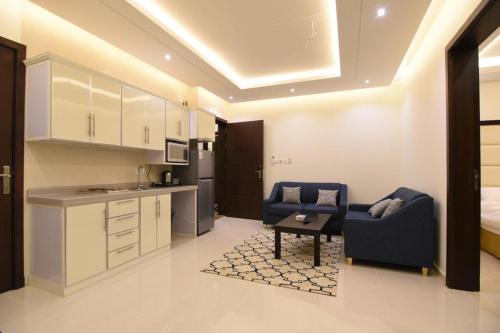 a kitchen with a couch and a table in a room at Golden White Hotel in Taif