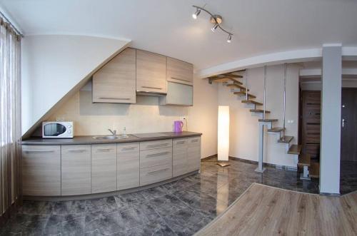 a kitchen with a staircase and a sink and a microwave at Apartamenty Giżycko in Giżycko