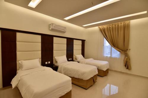 a bedroom with two beds and a window at Golden White Hotel in Taif