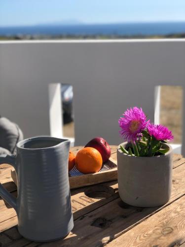 two cups and a flower on a wooden table at Harmony Luxury Villas Naxos in Naxos Chora