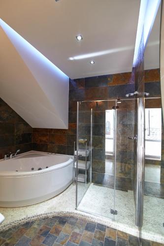 a large bathroom with a tub and a shower at Pidkova in Rivne