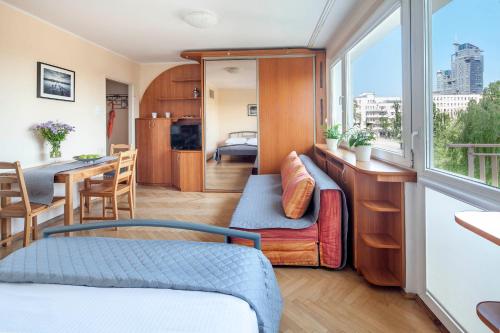 um quarto com uma cama, uma mesa e uma janela em Sleepy3city with Sea View em Gdynia