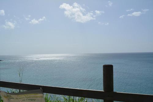 a view of the ocean from a fence at Middle Country 97-1 "la recette du bonheur" in Deshaies