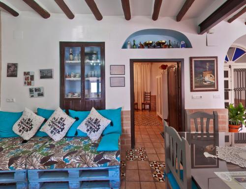 un salon avec un canapé bleu et des oreillers dans l'établissement Casa Rural La Casa De Maita, à Encinas Reales