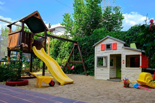 a playground with a slide and a play house at Casa Lotca in Costinesti