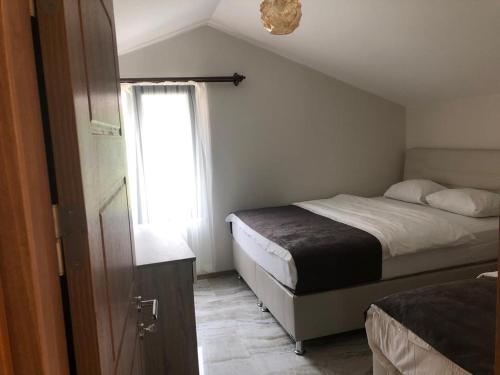 Horio Villa في أوزونغول: غرفة نوم صغيرة بسريرين ونافذة