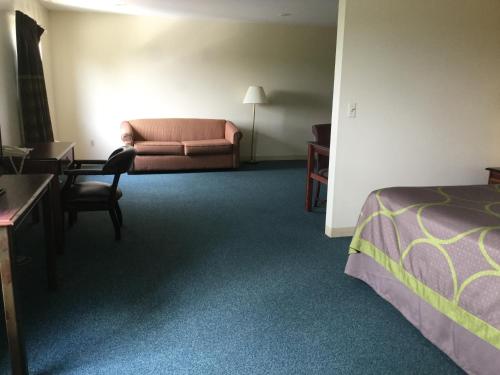 a hotel room with a bed and a couch at Super 8 by Wyndham Imlay City in Imlay City