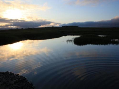 a body of water with the sunset in the background at Karrawa Guest House in Kirkwall