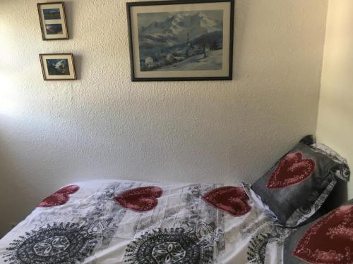 uma cama com uma colcha e fotografias na parede em appartement les deux alpes em Les Deux Alpes