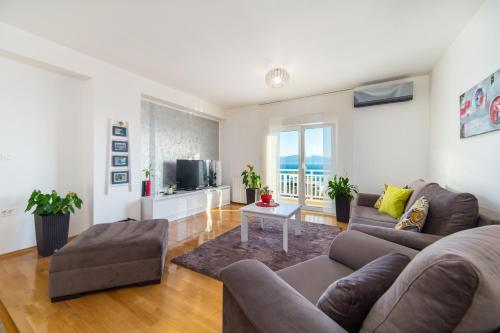 a living room with a couch and a tv at Apartments Mateljak in Gradac