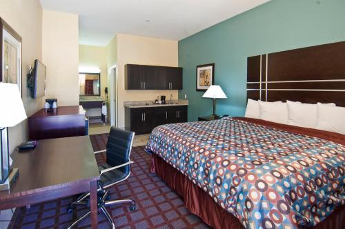 a hotel room with a bed and a desk at Executive Inn and Suites Tyler in Tyler