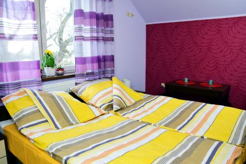 a bedroom with two beds with yellow and striped pillows at Ranczo u Stefana in Ustronie Morskie
