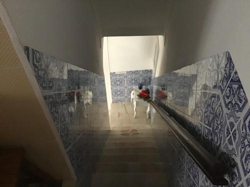 a person walking down a hallway with a painting on the wall at Casa Cardinho - A sua casa no Alentejo in Castelo de Vide