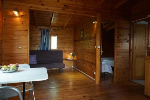 a room with a couch and a table in a cabin at Camping La Vall d'Hostoles in Sant Feliu de Pallerols