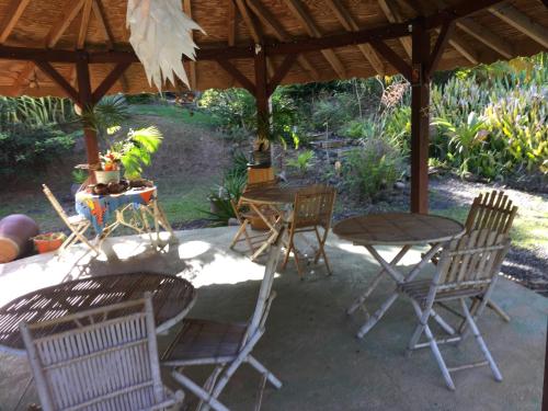a group of chairs and tables under a pavilion at Middle Country 97-1 "la recette du bonheur" in Deshaies