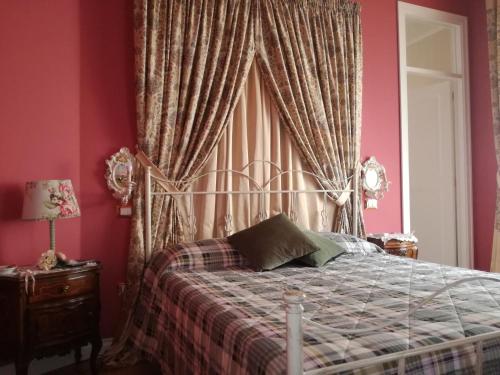 a bedroom with a bed with pink walls at La dimora del giurista in Rossano