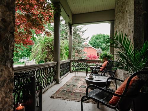 a woman sitting on the porch of a house at Rosemount Inn in Kingston