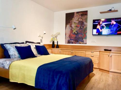 um quarto com uma cama e uma televisão na parede em Villa Yadranka em Strunjan