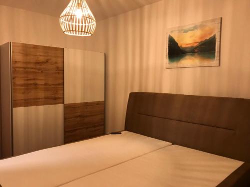 ein Schlafzimmer mit einem Bett und einer Hängeleuchte in der Unterkunft Diamond house in Hajdúszoboszló