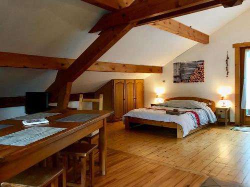a bedroom with a bed and a desk in a room at L'Ancolie in Le Reposoir