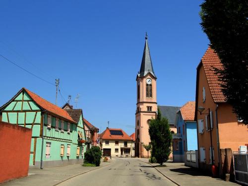 an empty street in a town with a church at Aux deux hirondelles in Houssen