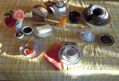 a table with breakfast foods on a yellow table cloth at B&B Calecatine in Rocca di Botte