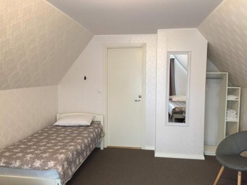 a small bedroom with a bed and a mirror at Tiigi Accommodation in Kärdla