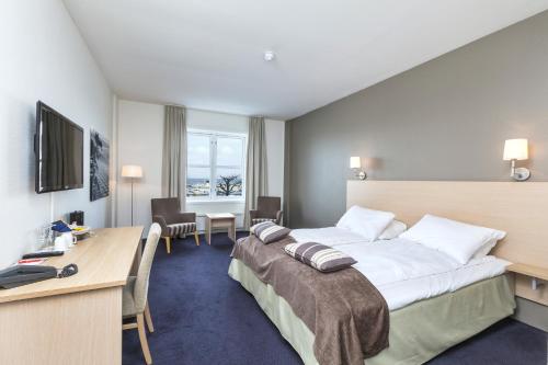 a hotel room with a large bed and a desk at Grand Hotel Åsgårdstrand - Unike Hoteller in Åsgårdstrand