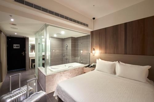 a bedroom with a bed and a bath tub at Grand Bay Resort Hotel in Hengchun