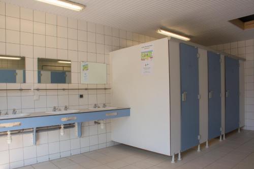 a bathroom with two sinks and two mirrors at Camping des Rochers des Parcs in Clécy