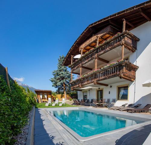 uma casa com piscina e varanda em Alpenresidenz Maria em Silandro